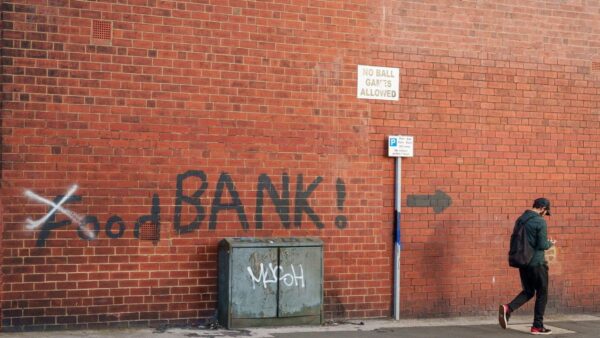 A person walks past a mural reading ‘Food Bank’ in the Harehills district of Leeds, UK