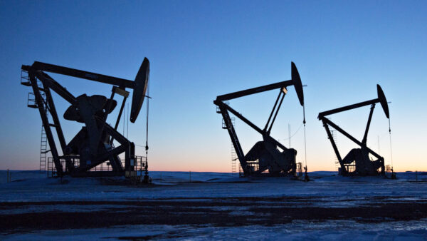Silhouettes of pumpjacks above oil wells