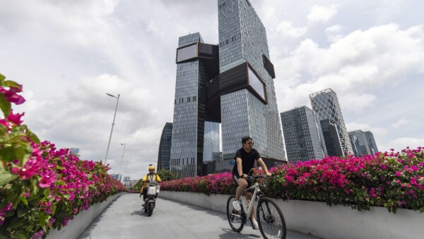 People cycle past the Tencent HQ in Shenzhen, Guangdong province, China