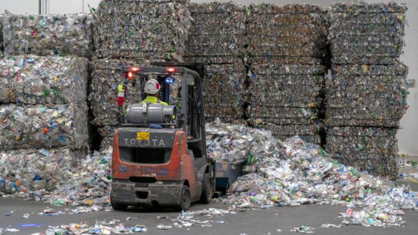 An employee uses a forklift to move bales of plastic bottles at the rPlanet Earth recycling plant in California