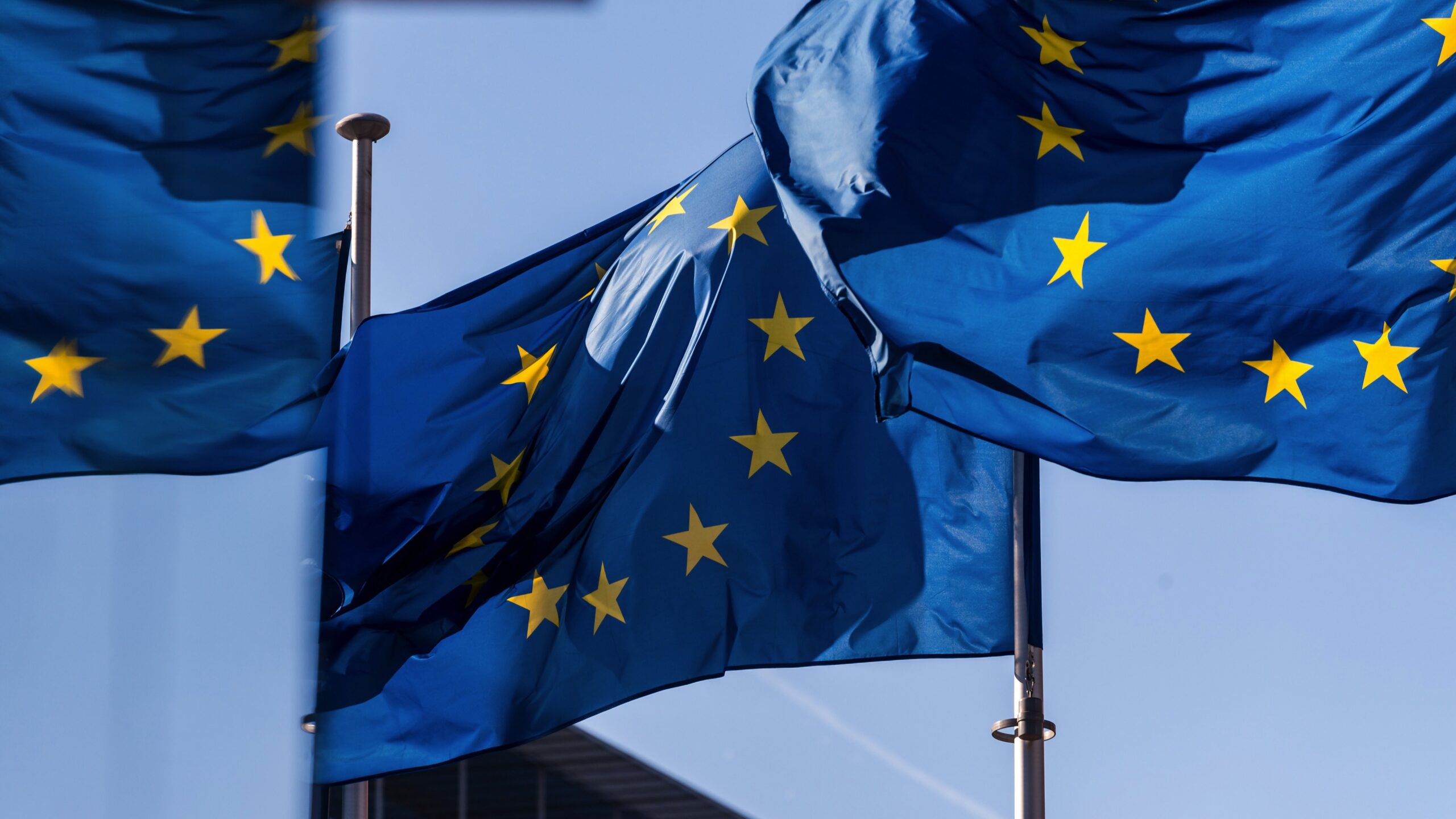 Sunlight falls across European Union flags in Brussels